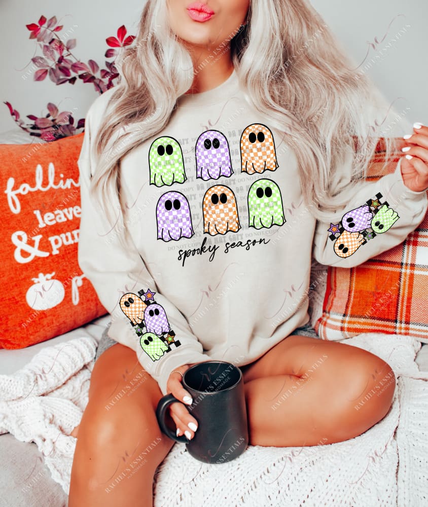 Checkered retro ghosts in orange, purple and lime green. Spooky season written in cursive font underneath ghosts.