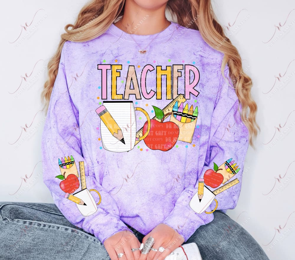 The word teacher in yellow and pink. Below is a pencil, paper mug, ruler, apple and box of crayons. Colored dots are surrounding the design